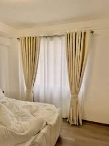 Energy saving curtains installed in a sunlit living room to reduce indoor heat